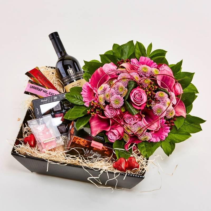 Gavekasse med vin, chokolade og buket i lyserøde farver
