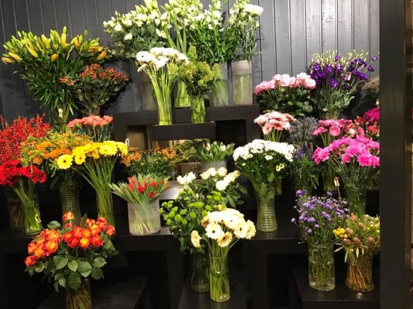 Afskårne blomster opstillet i butikken på podier.