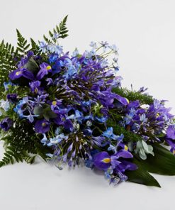 Bårebuket af årstidens blomster i blå/lilla farver.