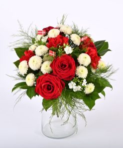 En lav tæt fødselsdagsbuket i hvid og rød. Buketten er pyntet med små danske flag.