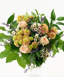 En lav buket bundet af creme roser, santini chrysanthemum, lilla limonium og voksblomster + grønt.