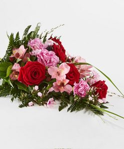 Bårebuket af årstidens blomster i rød og lyserød.