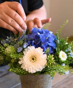 Buket i hvide og blå nuancer der arbejdes på.