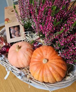 Kurv med lyngplanter, græskar og chokolade
