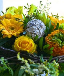 Nærbillede af et pynte påskeæg gule gerbera, roser og chrysanthemum