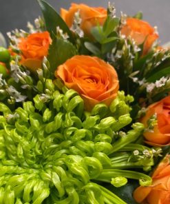 Nærbillede af orange roser og stor grøn chrysanthemum