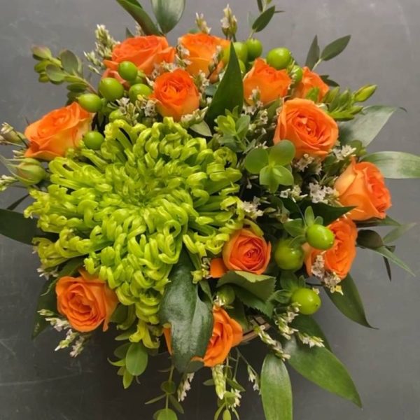 Nærbillede af blomsteræske med orange blomster.