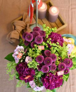 Buket i pink/lilla farver pyntet med små flag