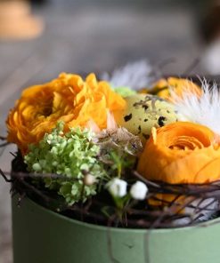 Nårbillede af gule ranunkler og et plettet påskeæg