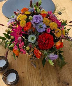 Hatteæske med farverige blomster på bord set oppefra