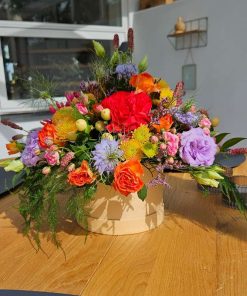 Hatteæske med farverige blomster på bord