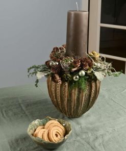 Juledekoration med bloklys og sølvkugler på et bord med en lille skål med småkager