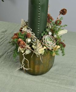 Kalenderlys juledekoration i grønne farver med naturpynt på bord med grøn dug