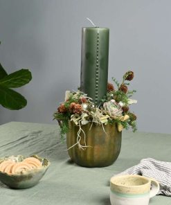 Kalenderlys juledekoration i grønne farver med naturpynt på bord med grøn dug