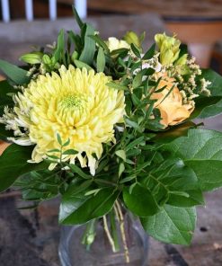 Buket i gule nuancer med en stor gul chrysanthemum i fokus