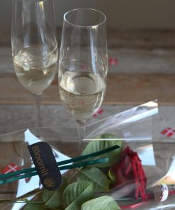 To glas champagne og en rød rose liggende