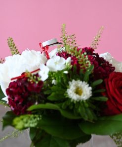 Buket i hvid og rød med lille rød studenterhue set fra siden