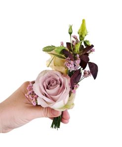 Knaphulsblomst holdes i hånd, med lilla rose og andre blomster