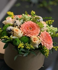 Blomsteræske med forskellige blomster og små påskeæg