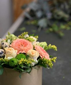 Blomsteræske med forskellige blomster og små påskeæg