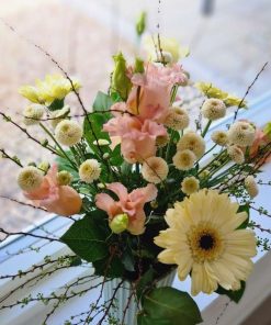 En buket i lyserøde og lysegule farver set oppefra