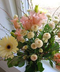 En buket i lyserøde og lysegule farver set oppefra