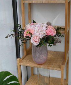 Buket i lyserøde farver på en reol