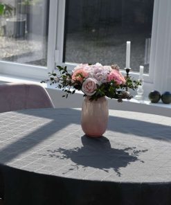 Buket i lyserøde farver på et bord med grå dug