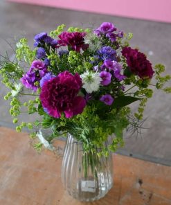 Buket i lilla farver i glasvase