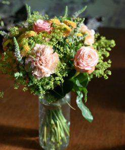 Buket med lyesrøde blomster i solskin