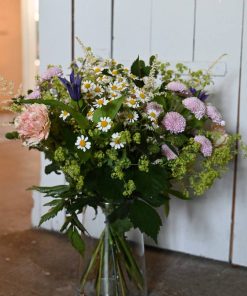 Buket med lyse blomster i glasvase