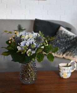 Buket i blå og lime farver på teakbord foran sofa