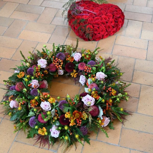 Begravelseskrans og blomsterhjerte på kirkegulvet