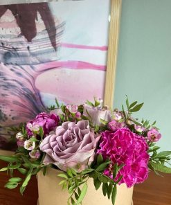 Billede af en lilla blomsteræske med et lillafarvet maleri i baggrunden