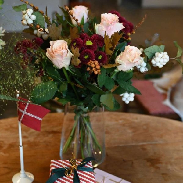 Buket med ferskenfarvede roser, chrysanthemum , snebær og efterårsgrene