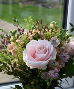 Buket med lyserøde roser, og andre lyserøde blomster som astrantia, limolium, leukøjer og forskelligt grønt