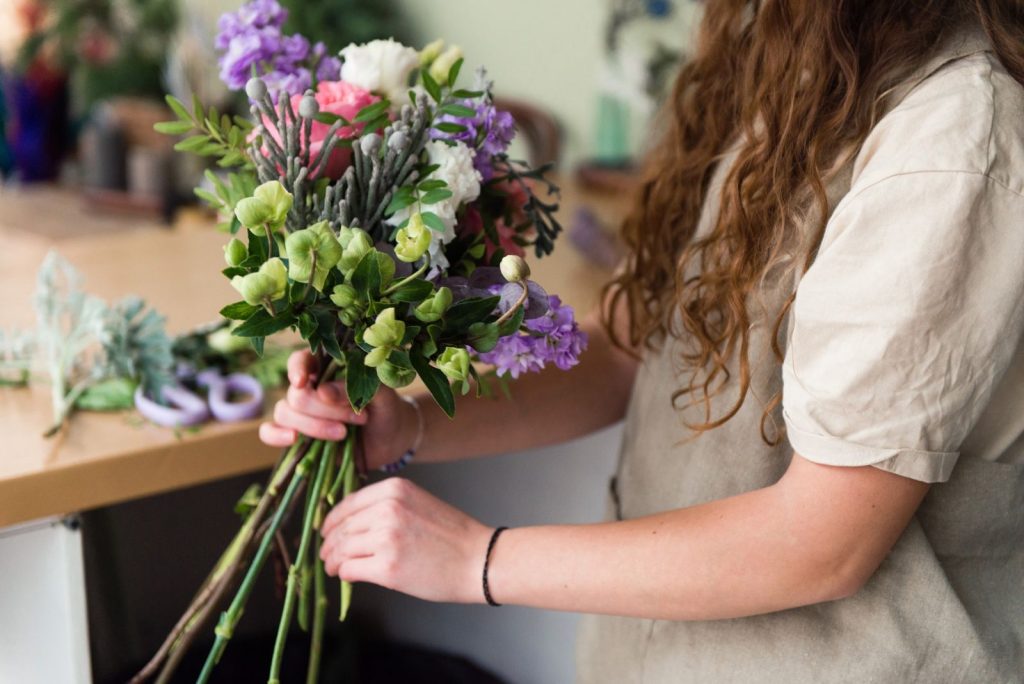 En blomsterdekoratør binder en buket