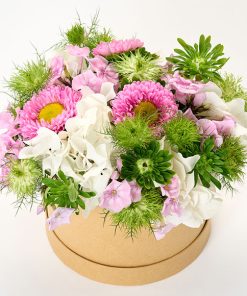 Sommerdekoration i lyse farver i en rund blomsteræske.