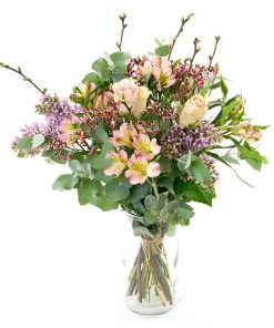 En forårsbuket i luftig deasign, bundet af lyser forårsblomster.