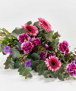 Bårebuket med blomster i pink og lilla.