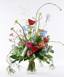 Variationsbuket i ekstraordinær stor størrelse. Buketten er bundet af mange forskellige blomster i friske farver og pyntet med en nytårsknallert i sølv.