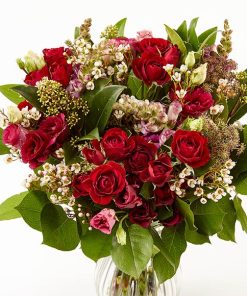 En smuk buket af røde grenroser, og andre rødlige blomster.