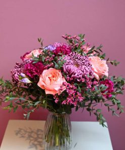 buket i lyserøde og lilla farver i glasvase