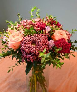 Buket i lyserøde og lilla farver i glasvase