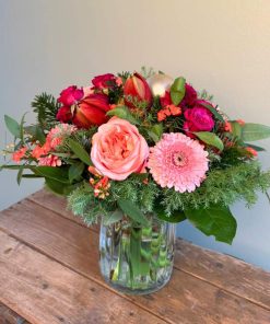 Buket i lyserøfe og røde farver med julekugler og amaryllis