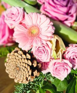 Nærbillede af lyserøde blomster og grankogle