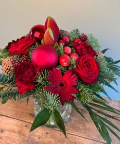 rød julebuket med julekugler i glasvase