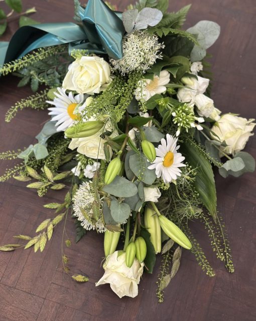 En bårebuket bundet af hvide blomster